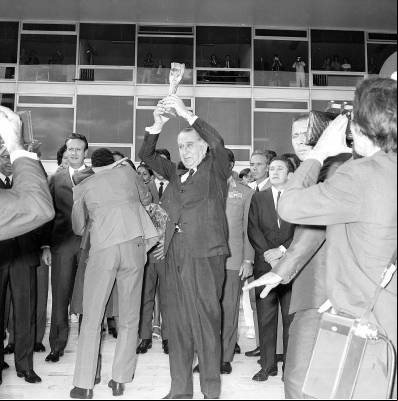 Médici ergue a taça Jules Rimet, conquistada pela Seleção Brasileira na Copa do Mundo de Futebol de 1970 no México, na rampa do Palácio do Planalto